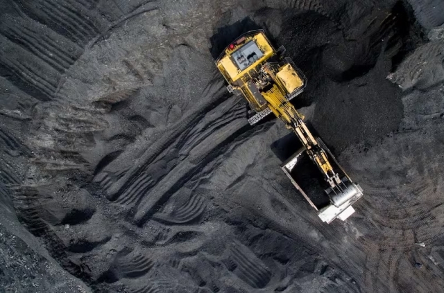 A massive excavator operating in a coal pit, extracting valuable resources from the earth's depths.
